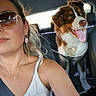 woman, dog, car, seatbelt, sunglasses, white_top, dog_harness, pet, backseat, portrait, smile, happy, interior, travel, road_trip, sunlight, leisure, safety, canine, passenger