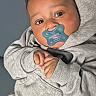 baby, pacifier, hoodie, grey_clothing, infant, cute, hands, portrait, face, young_child, indoors, soft_lighting, expression, comfortable, casual, sitting, child, looking_at_camera, skin, head