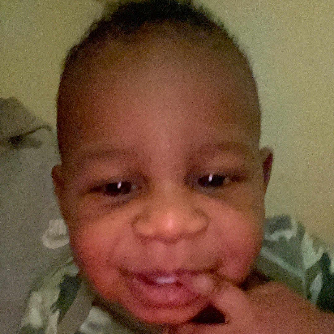 Oshian is registered to the contest to win money with this photo: baby, camouflage, cheek, child, clothing, cute, expression, eyes, face, fingers, hand, head, indoor, mouth, nose, person, portrait, skin, smile, toddler