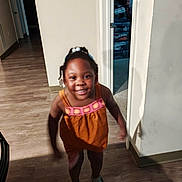 Mailonnye is registered to the contest to win money with this photo: child, girl, smiling, orange_dress, sandals, hair_beads, indoor, hallway, wood_floor, doorway, clothing, person, motion_blur, happy, young_child, shadow, room, home_interior, casual, portrait