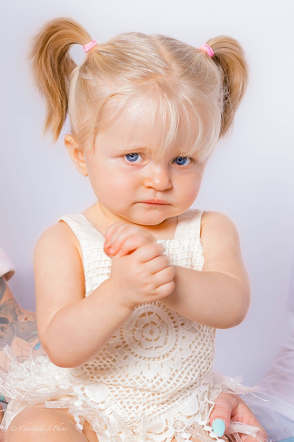 Anya participe au concours pour gagner de l'argent avec cette photo : arm, baby_toddler_clothing, cheek, child, day_dress, dress, embellishment, eyelash, flash_photography, gesture, happy, headpiece, iris, jewellery, lip, neck, person, pink, skin, toddler