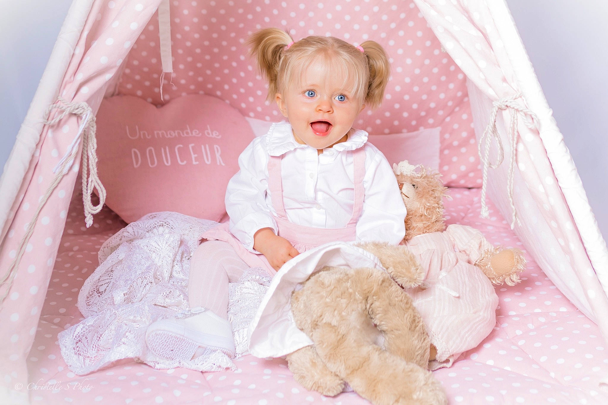 Anya a rejoint le concours — aidez-le/la à gagner de superbes lots ! baby_products, baby_toddler_clothing, bridal_accessory, chair, child, comfort, doll, dress, embellishment, event, happy, linens, peach, person, pink, room, sitting, sleeve, textile, toddler