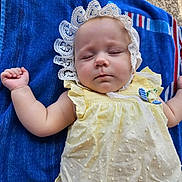 Nadia joined the competition — help win amazing prizes! baby, sleeping, yellow_dress, lace_bonnet, towel, blue_towel, infant, child, peaceful, resting, soft_skin, closed_eyes, cute, adorable, outdoor, texture, fabric, summer, relaxation, portrait