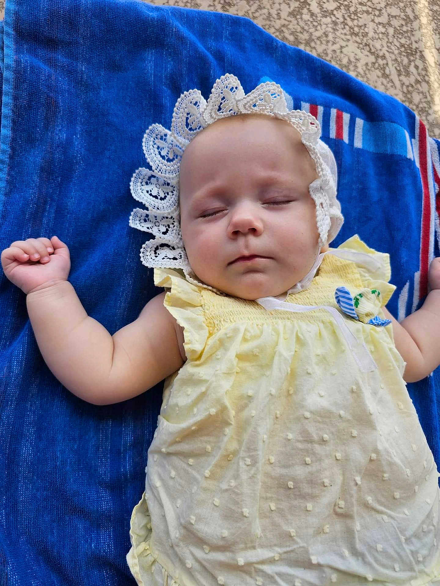 Nadia joined the competition — help win amazing prizes! baby, sleeping, yellow_dress, lace_bonnet, towel, blue_towel, infant, child, peaceful, resting, soft_skin, closed_eyes, cute, adorable, outdoor, texture, fabric, summer, relaxation, portrait