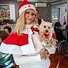Monk a rejoint le concours — aidez-le/la à gagner de superbes lots ! background, cape, chair, community, dog, festive, glasses, hat, holding, holiday_clothing, indoor, light, people, red_and_white, small_dog, smiling, tiles, wheelchair, window, woman
