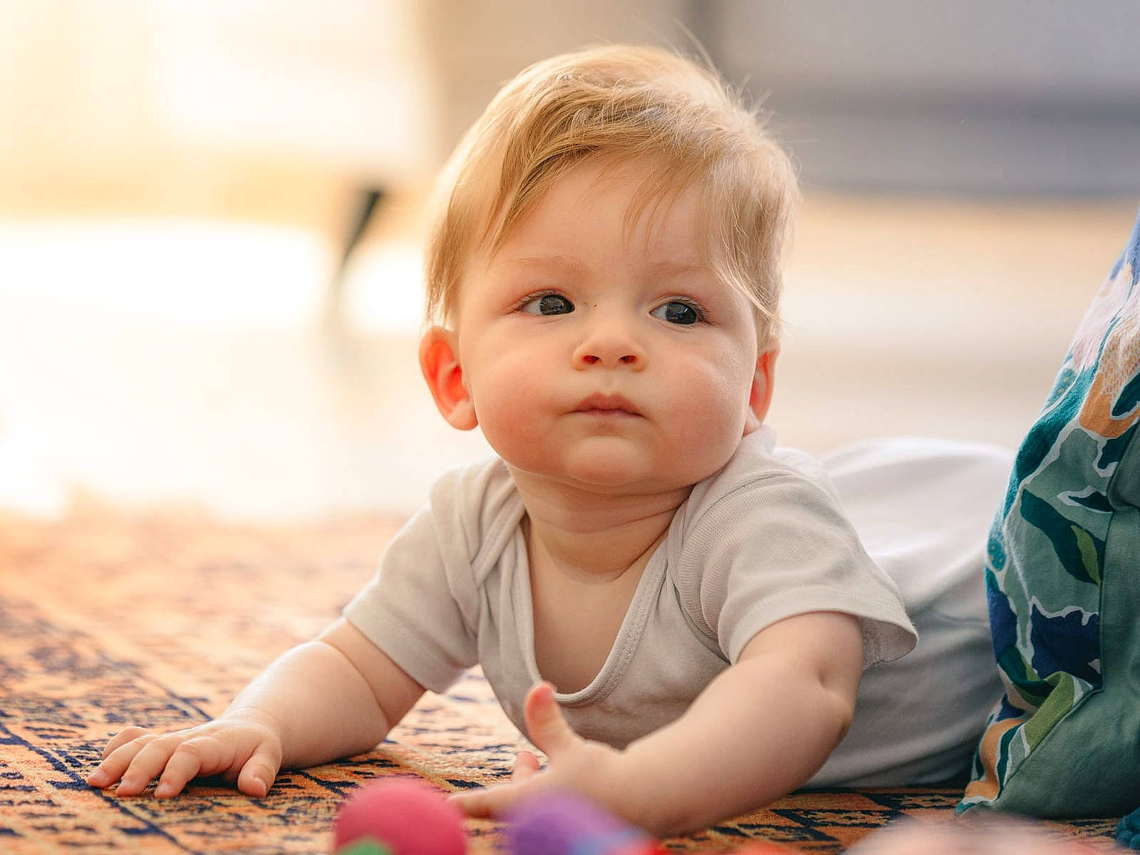 Marin participe au concours pour gagner de l'argent avec cette photo : baby, baby_playing_with_toys, baby_toddler_clothing, cheek, child, eye, face, flooring, fun, grass, happy, iris, leisure, people_in_nature, person, sitting, skin, smile, toddler, tummy_time