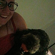 Nala is registered to the contest to win money with this photo: casual, companion, cozy, curly_hair, cute, dark, dog, face, friendship, furry, glasses, happy, home, indoor, person, pet, red_tank_top, selfie, smile, tongue_out