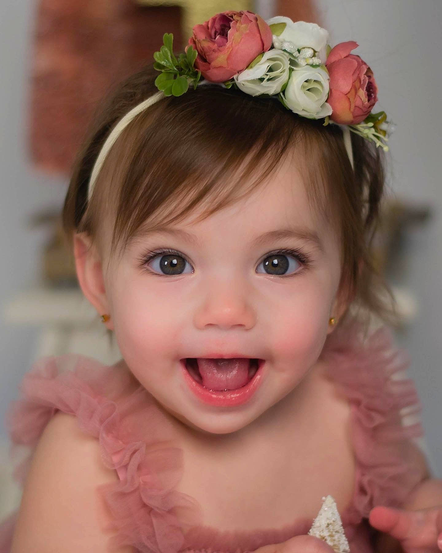 Maggie is registered to the contest to win money with this photo: child, dress, eye, eyelash, face, flower, happy, head, headband, headgear, headpiece, iris, jewellery, lip, person, petal, pink, plant, skin, smile