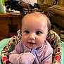 Miley is registered to the contest to win money with this photo: baby, child, pigtails, purple_sweater, baby_seat, indoor, curious, cute, face, person, smiling, infant, young_child, seated, colorful, cozy, portrait, home, furniture, soft_lighting