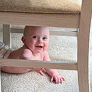 Aaliyah is registered to the contest to win money with this photo: baby, child, smiling, happy, crawling, carpet, wooden_chair, indoor, cute, infant, skin, person, playful, face, hand, floor, furniture, expression, eyes, body
