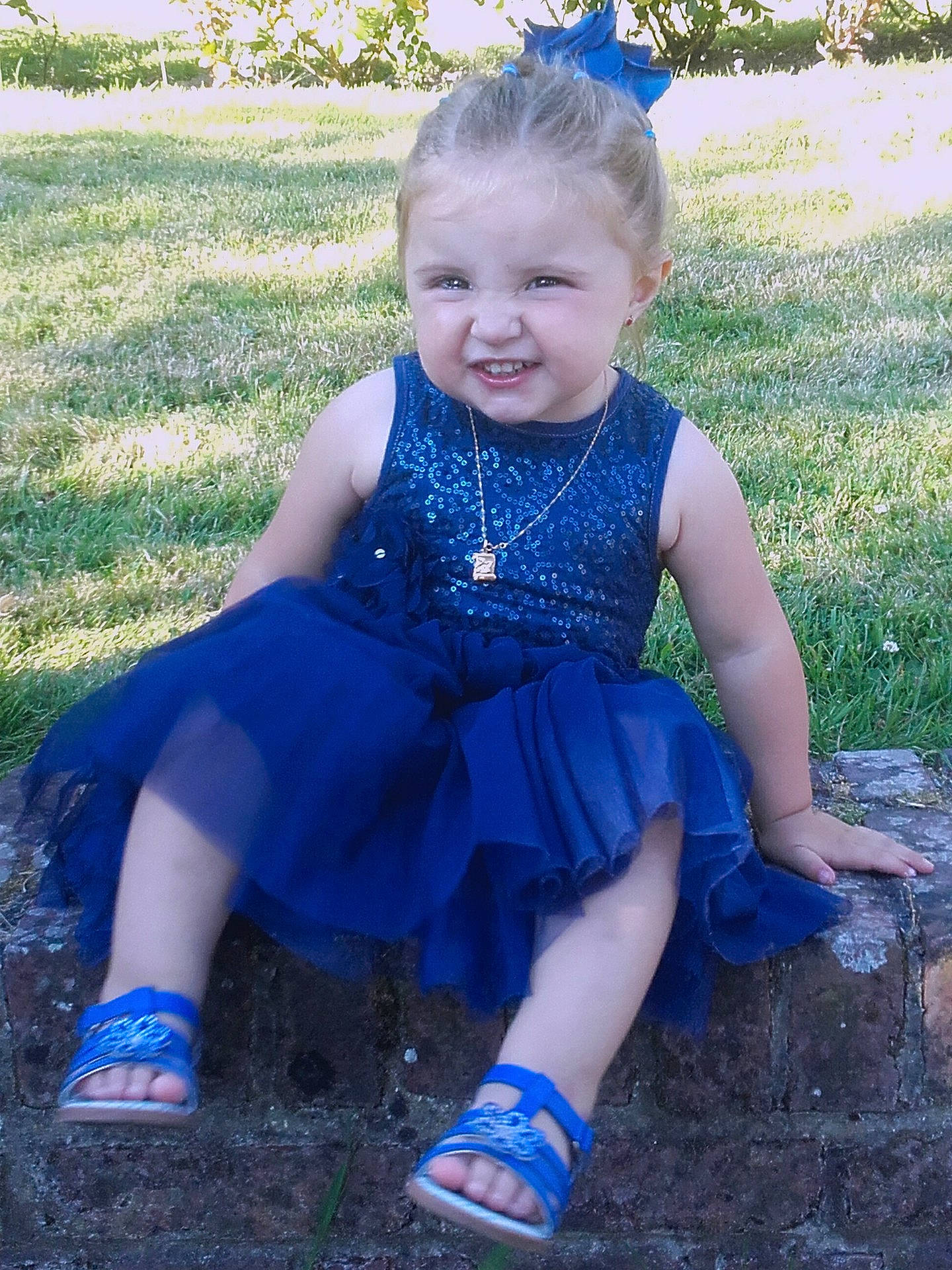 Beverly participe au concours pour gagner de l'argent avec cette photo : blue, child, clothing, day, dress, electric_blue, facial_expression, fun, girl, grass, happiness, infant, joy, leg, outerwear, person, sitting, skin, smile, standing