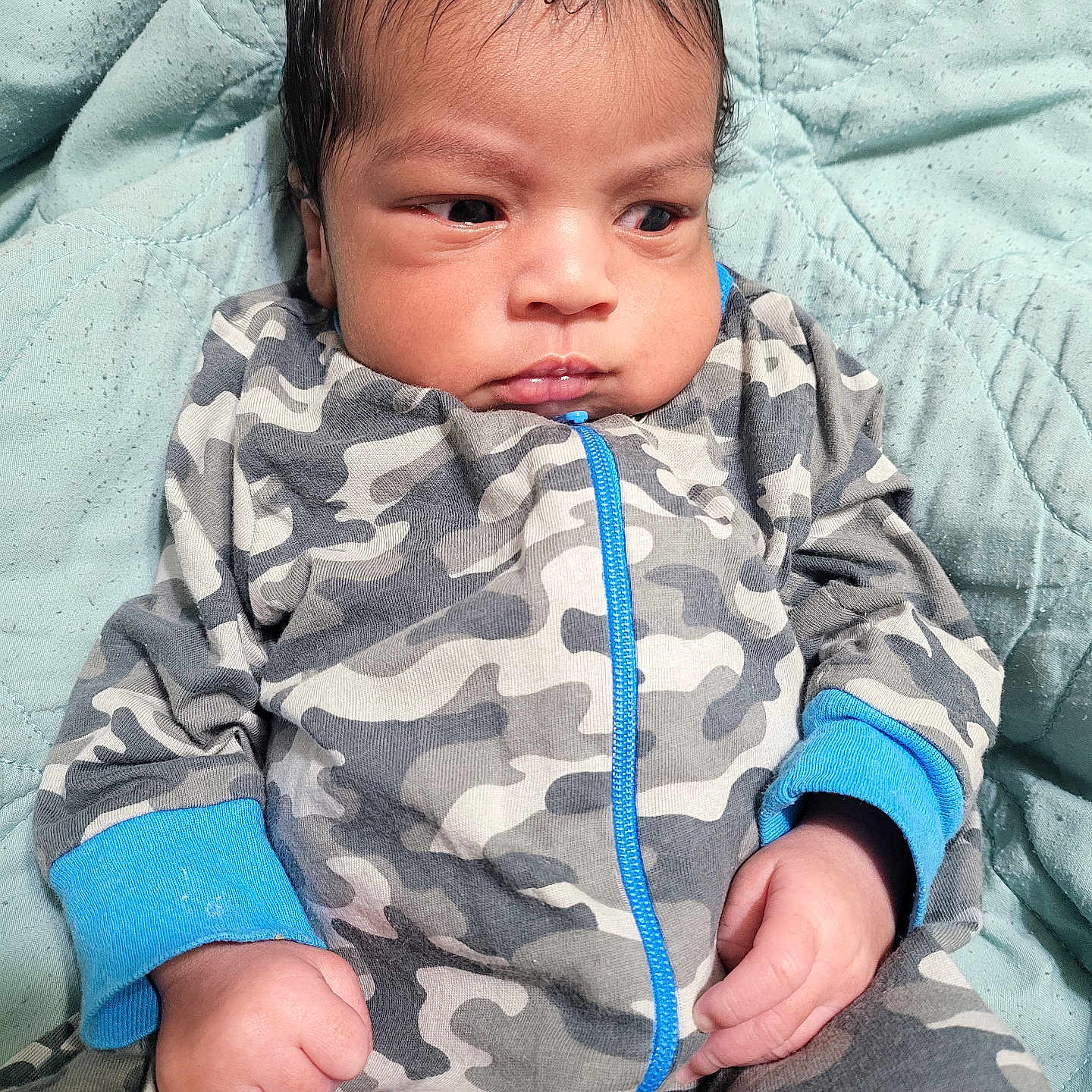 Kingston Curtis joined the competition — help win amazing prizes! baby, blanket, blue_cuffs, camouflage, casual, child, clothing, cute, expression, face, hands, indoors, infant, newborn, onesie, portrait, quilted, resting, soft_texture, young_child