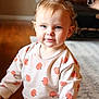toddler, child, indoor, pumpkin_pattern, sweater, balloon, curly_hair, pony_tail, blue_eyes, carpet, couch, person, floor, soft_light, happy, smile, cute, home, portrait, casual_clothing