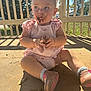 toddler, child, dirt, face, hands, shoes, pink_clothing, sunlight, porch, outdoor, shadow, headband, expression, sitting, concrete_floor, nature, daylight, casual, playful, messy
