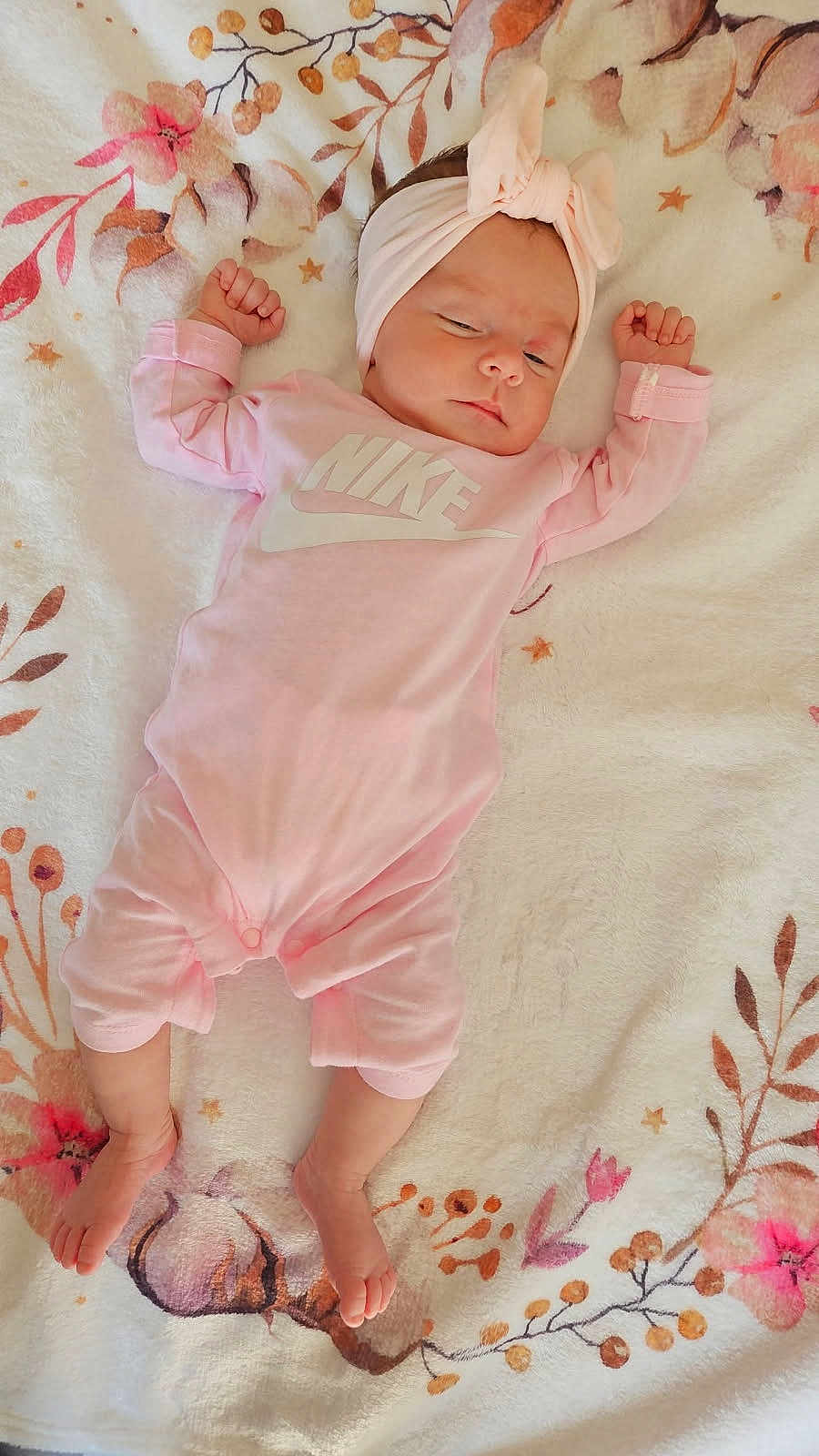 Romy participe au concours pour gagner de l'argent avec cette photo : baby, infant, pink_clothing, headband, blanket, floral_pattern, sleeping, arms_up, legs_stretched, soft_texture, indoors, cute, newborn, face, person, foot, hand, toddler, resting, comfortable