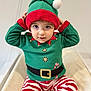 Nathéo a rejoint le concours — aidez-le/la à gagner de superbes lots ! toddler, child, elf_costume, green_hat, red_and_white_stripes, holiday_outfit, cute, festive, indoor, smiling, baby, portrait, sitting, clothing, hat, striped_pants, holiday_theme, innocent, young_child, playful
