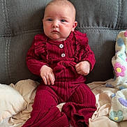Octavia joined the competition — help win amazing prizes! baby, blanket, child, colorful_blanket, comfortable, cozy, cute, gray_couch, home, indoor, infant, knitted_outfit, person, portrait, red_clothing, serious_expression, sitting, soft_lighting, warm, young_child