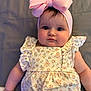 baby, child, infant, pink_bow, headband, floral_dress, cute, portrait, closeup, soft_lighting, laying_down, chubby_cheeks, young_child, indoor, person, adorable, fashion, baby_fashion, smile, face