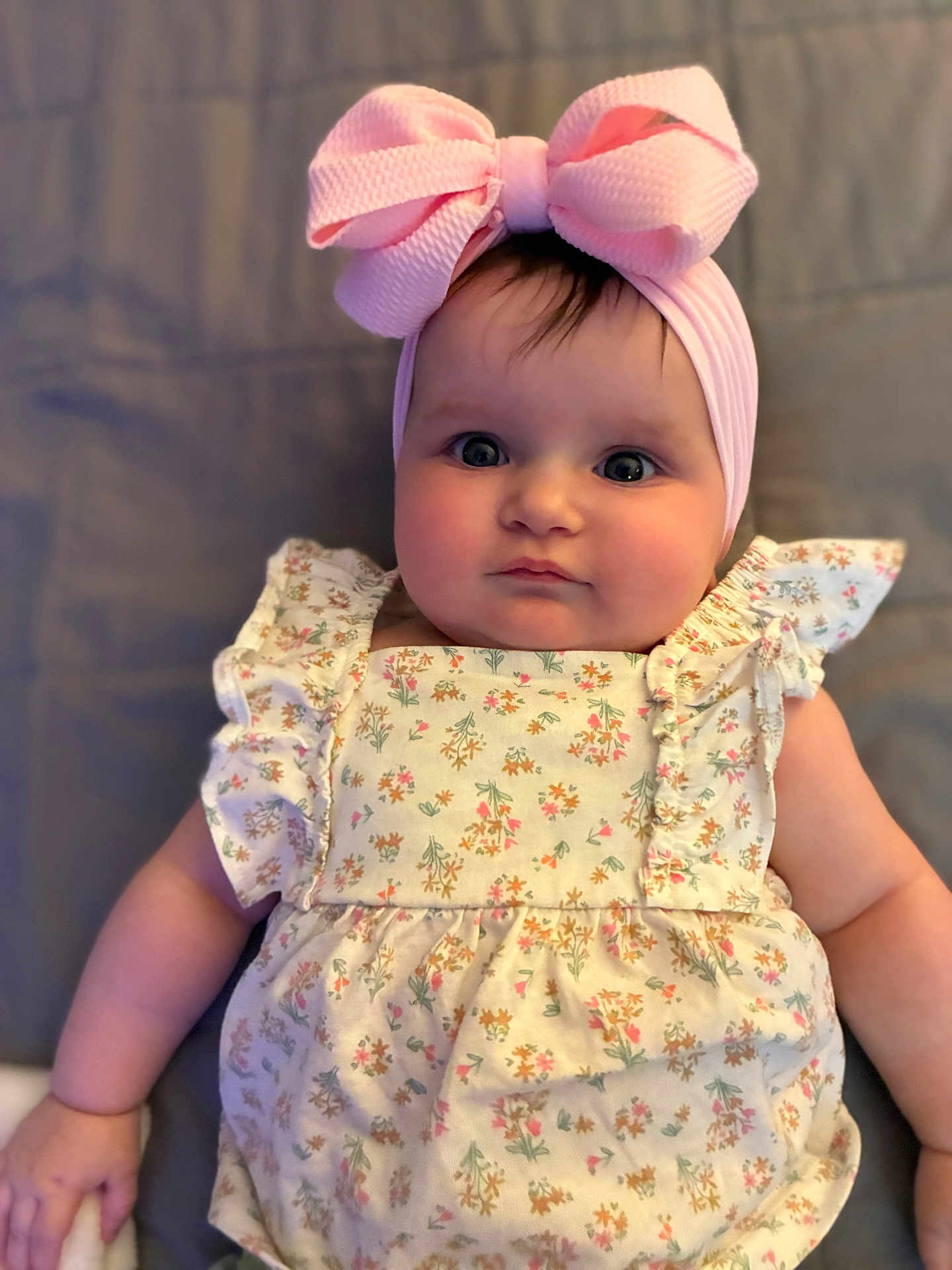 Espyn joined the competition — help win amazing prizes! baby, child, infant, pink_bow, headband, floral_dress, cute, portrait, closeup, soft_lighting, laying_down, chubby_cheeks, young_child, indoor, person, adorable, fashion, baby_fashion, smile, face