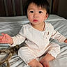 Natalie is registered to the contest to win money with this photo: baby, child, pajamas, bed, bedding, cute, indoors, portrait, person, infant, soft_toys, headband, expression, curious, sitting, sleepwear, face, skin, hair, earrings