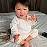 toddler, child, baby, pajamas, bed, white_bed, smiling, happy, indoor, person, face, hair, hands, feet, remote_control, headband, cute, cozy, casual, portrait