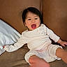 baby, child, pajamas, smiling, laughing, face, foot, couch, pillow, indoor, person, cute, happy, young_child, home, infant, cozy, relaxed, clothing, portrait
