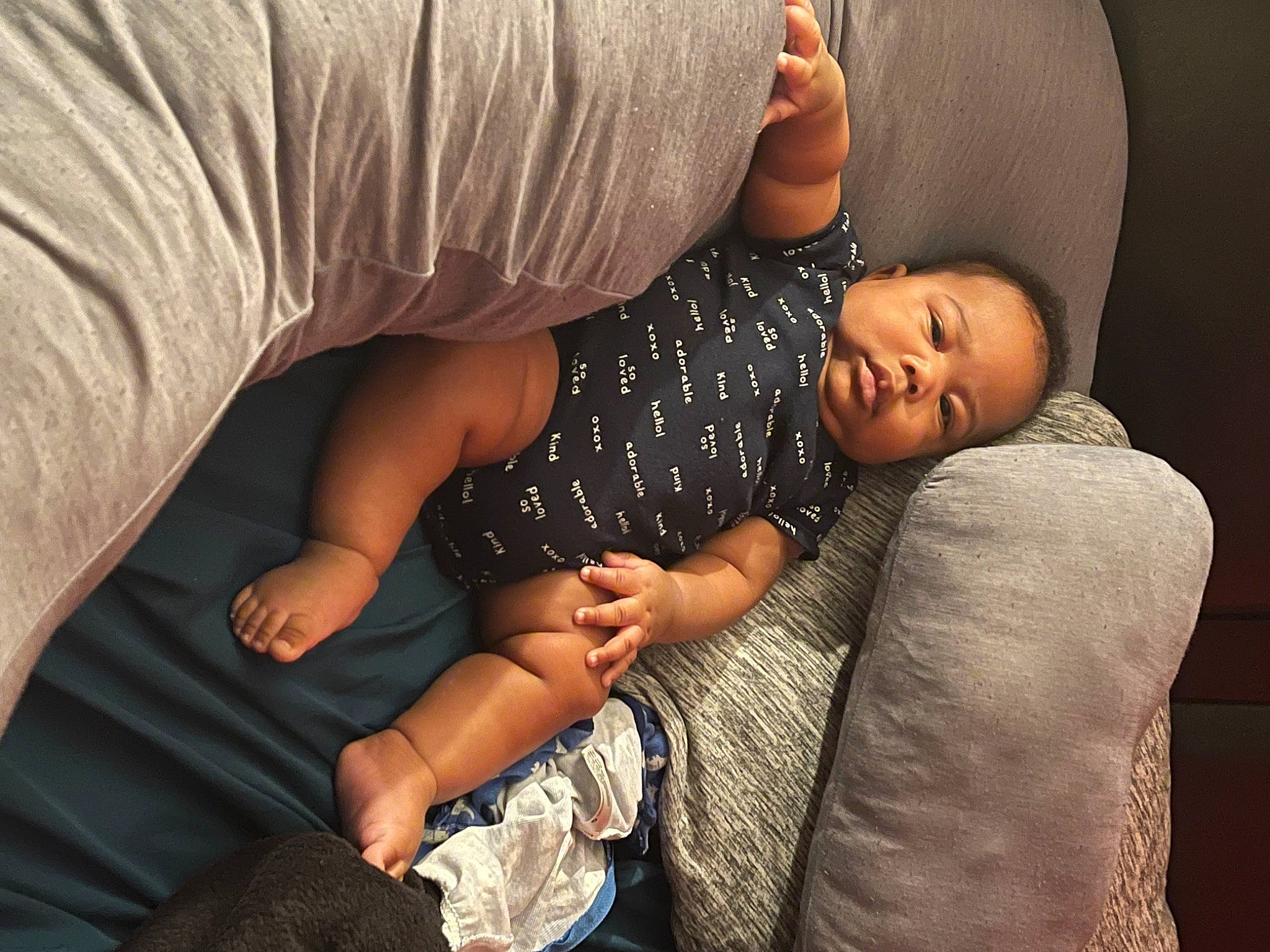 Denzel is registered to the contest to win money with this photo: abdomen, baby, black_hair, child, comfort, elbow, finger, flash_photography, gesture, glasses, happy, human_leg, joint, knee, nail, person, sitting, sleeve, thigh, toddler