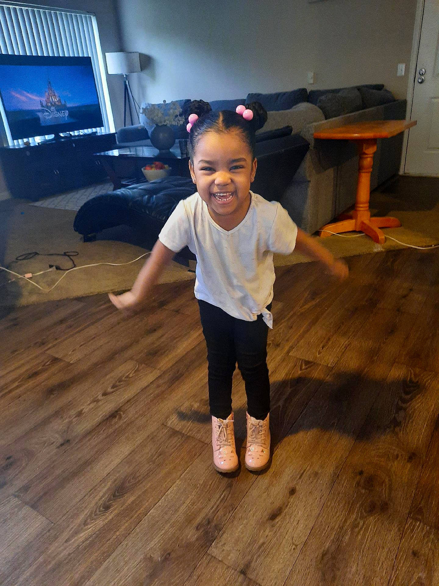 Lareina is registered to the contest to win money with this photo: child, face, floor, flooring, fun, happy, hardwood, home_appliance, human_leg, joy, laminate_flooring, person, smile, standing, t_shirt, table, television, toddler, varnish, wood