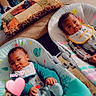 babies, infants, twins, siblings, children, faces, portrait, smiling, seated, bouncers, baby_gear, bib, blanket, cushion, indoors, home, carpet, colorful, heart_overlay, date_text