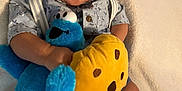 Isaiah is registered to the contest to win money with this photo: baby, child, plush_toy, cookie_monster, stuffed_animal, yellow_cookie, blue_socks, patterned_shirt, cute, wide_eyes, surprised_expression, baby_clothes, soft_blanket, indoors, portrait, cuddly, comfort, sitting, toy, infant