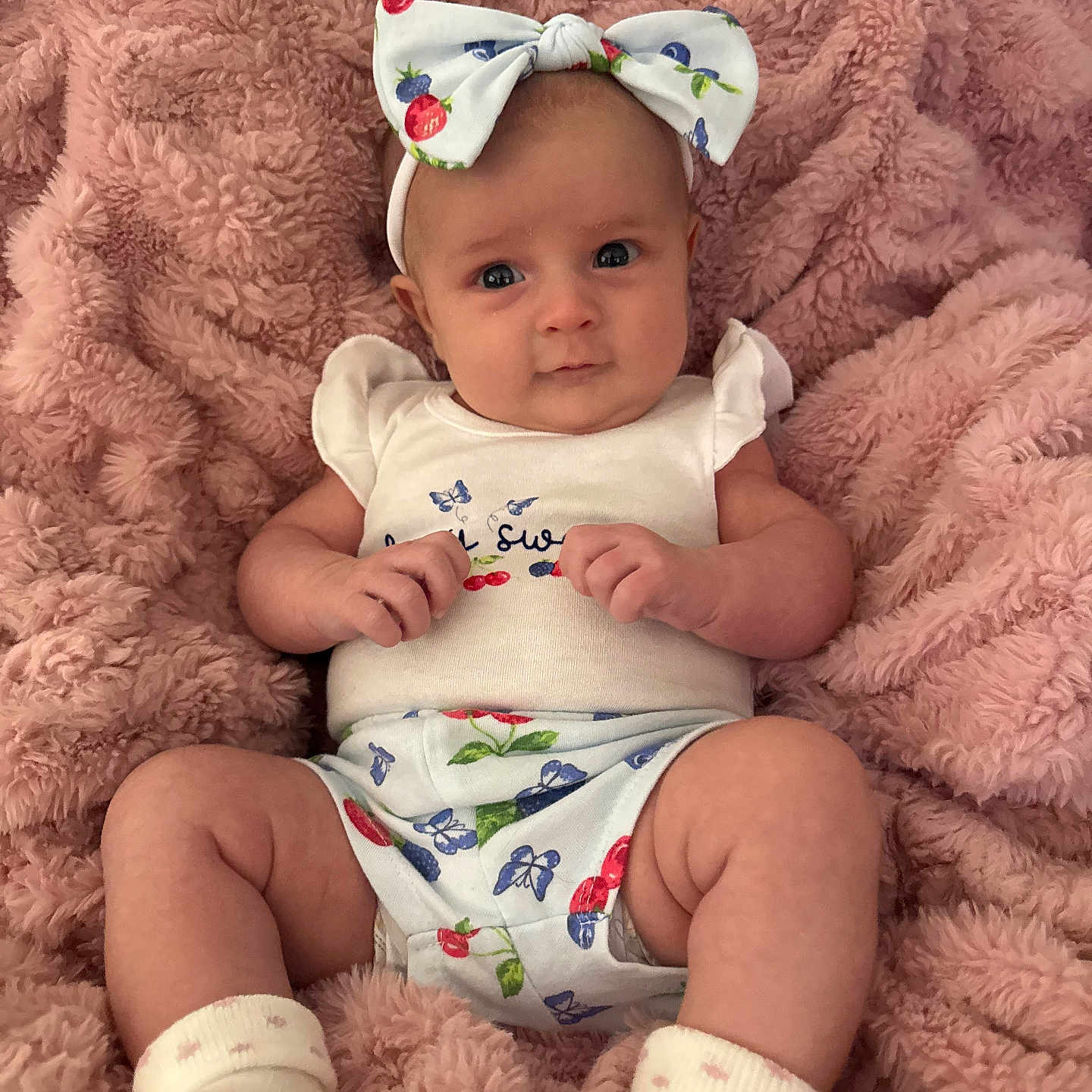 Avery joined the competition — help win amazing prizes! baby, infant, child, bow, headband, blanket, pink, clothing, socks, cute, portrait, lying_down, soft_texture, patterned_outfit, small_hands, wide_eyes, indoor, cozy, newborn, comfortable