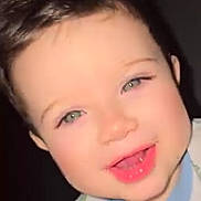Jonathan is registered to the contest to win money with this photo: baby, bright_eyes, child, colorful_clothing, cute, dark_background, face, happy, head_and_shoulders, human, indoors, person, portrait, rosy_cheeks, screenshot, smiling, social_media, text_overlay, toddler, young_child