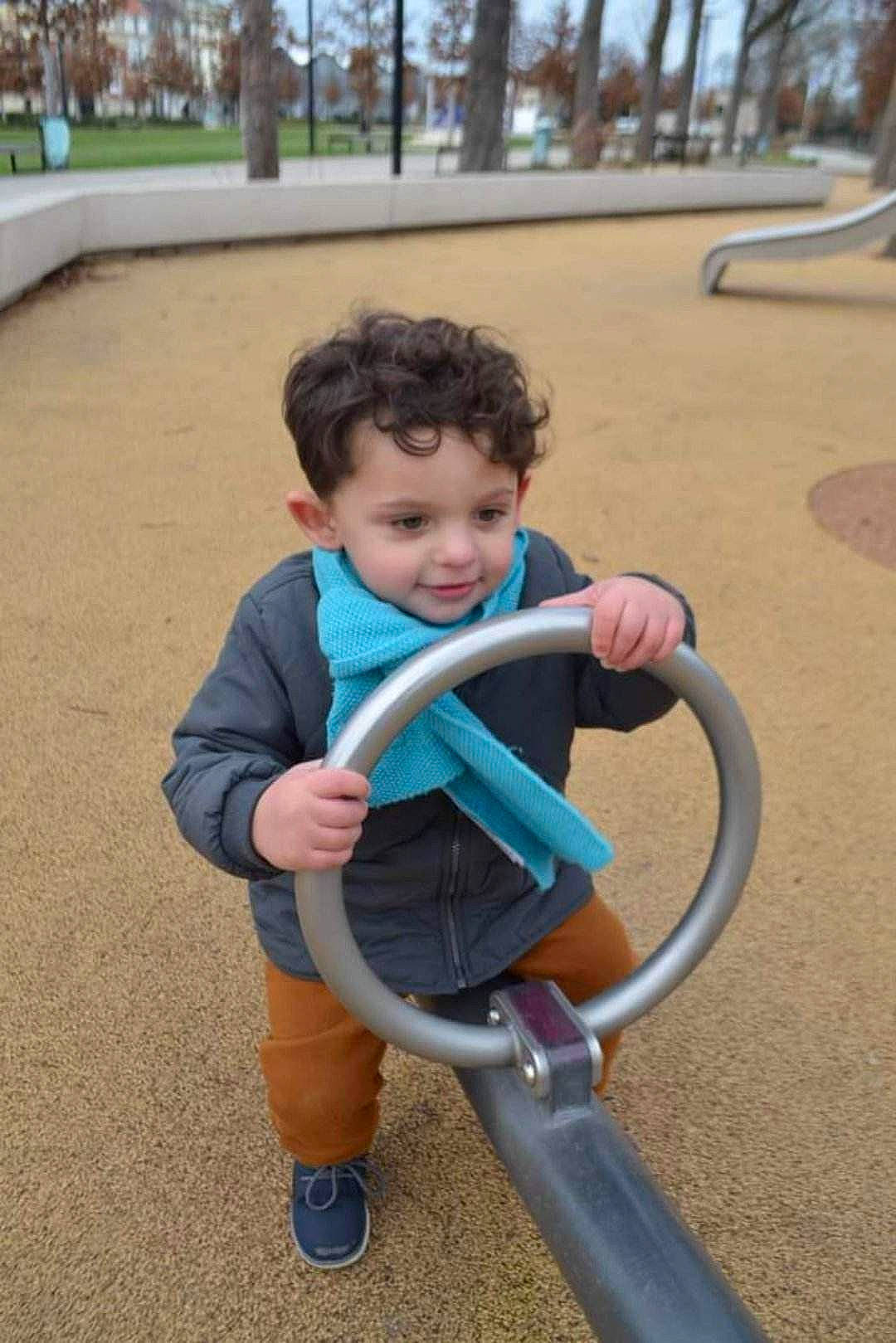 Florian participe au concours pour gagner de l'argent avec cette photo : baby, baby_products, baby_toddler_clothing, child, city, electric_blue, fun, grass, happy, leisure, outdoor_play_equipment, person, playground, public_space, recreation, sitting, smile, swing, tire, toddler