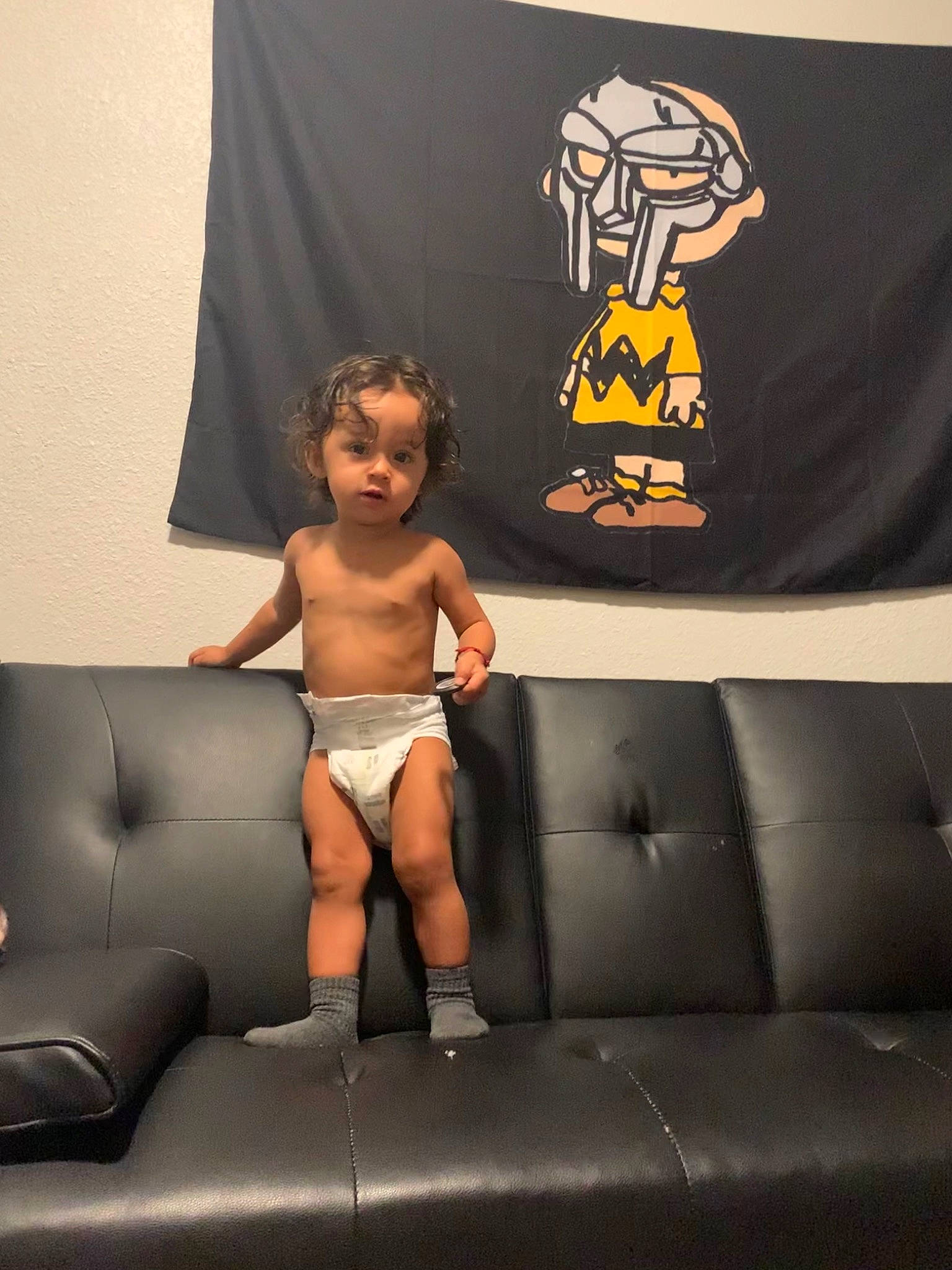 Apollo is registered to the contest to win money with this photo: black, chest, comfort, couch, fashion_accessory, flooring, human_leg, knee, living_room, logo, mammal, person, rectangle, room, sitting, sleeve, sofa_bed, t_shirt, textile, thigh