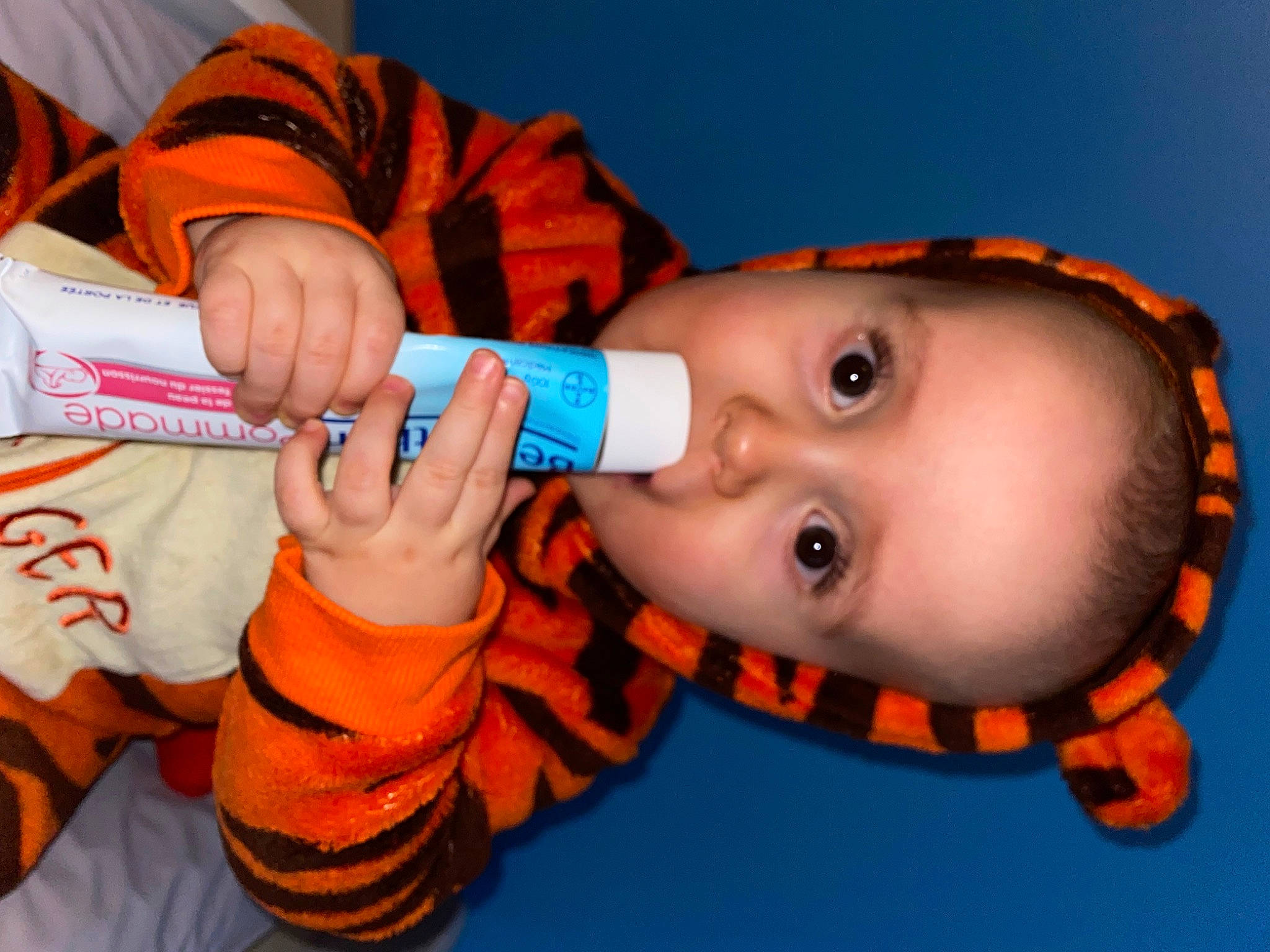 Thybo participe au concours pour gagner de l'argent avec cette photo : baby, baby_toddler_clothing, cheek, child, drinkware, electric_blue, eyelash, finger, fun, gesture, happy, human_body, lip, mouth, nail, nose, orange, person, skin, thumb