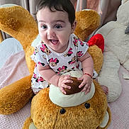 Lilianna is registered to the contest to win money with this photo: baby, child, toddler, plush_toy, teddy_bear, dress, pattern, minnie_mouse, smile, happy, indoors, bed, blanket, curtains, person, cute, soft_toy, sitting, playful, joyful