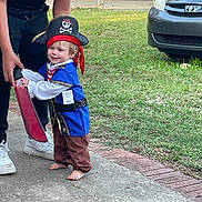 Lucas joined the competition — help win amazing prizes! child, toddler, pirate_costume, hat, foam_sword, barefoot, outdoor, grass, sidewalk, adult_hand, smile, toy, play, costume, car, vehicle, person, fun, daylight, casual
