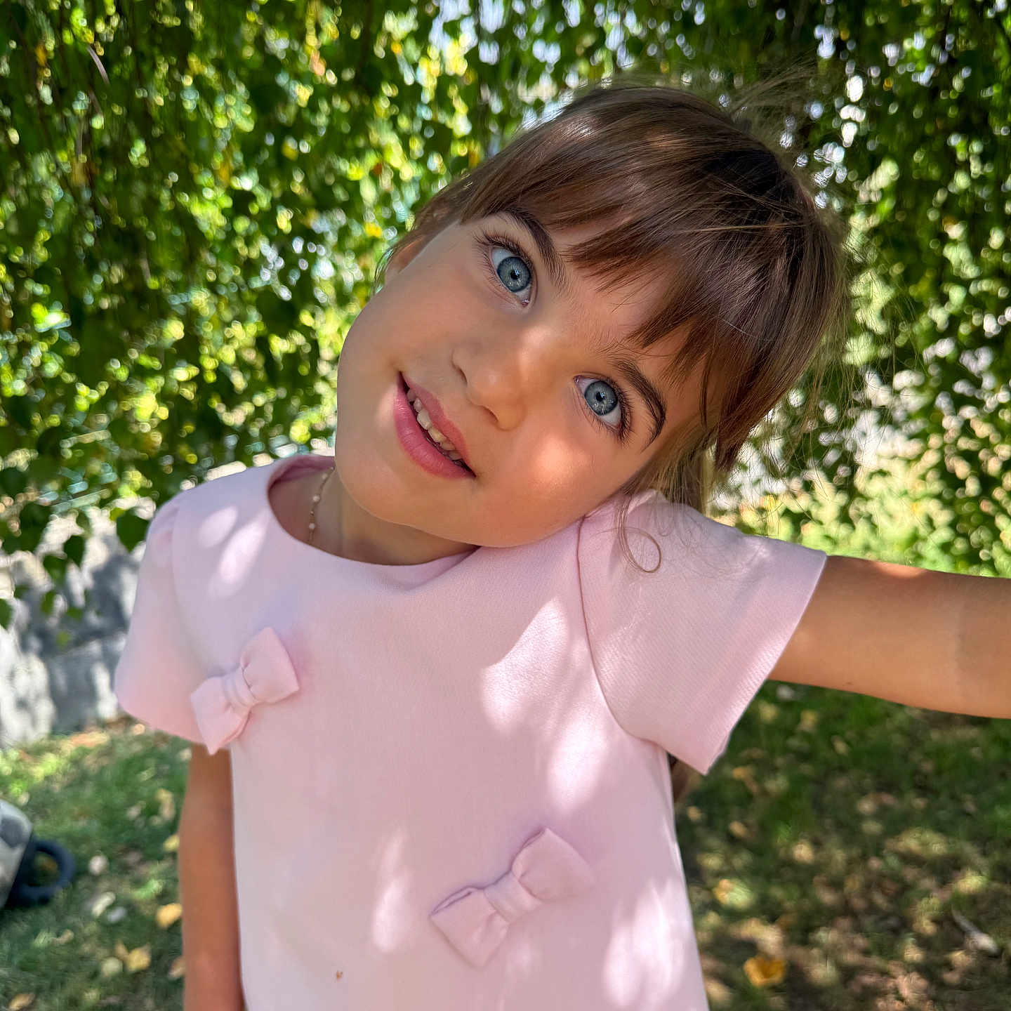 Giulia a rejoint le concours — aidez-le/la à gagner de superbes lots ! blue_eyes, bows, child, cute, face, girl, grass, greenery, happy, leaves, nature, outdoor, pink_dress, playful, portrait, shadow, smile, sunlight, tree, young