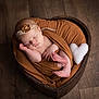 Alix a rejoint le concours — aidez-le/la à gagner de superbes lots ! newborn, baby, sleeping, wrapped, blanket, headband, flower, heart_shaped_bowl, wooden_floor, soft_toy, white_heart, peaceful, infant, cute, portrait, indoors, resting, cozy, wrapped_in_blanket, tender