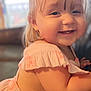 toddler, child, smiling, happy, blonde_hair, pink_dress, indoor, portrait, closeup, cute, baby, face, cheeks, ruffles, person, young_child, candid, soft_light, background_blur, playful
