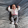 Judith participe au concours pour gagner de l'argent avec cette photo : baby, smiling, infant, blanket, gray_blanket, cardigan, red_buttons, gray_pants, white_socks, happy, cute, lying_down, raised_arms, soft_texture, indoors, child, portrait, cozy, warm_clothing, small_feet