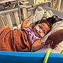 Amira joined the competition — help win amazing prizes! child, hospital, bed, blanket, medical_equipment, nasal_cannula, smile, person, indoor, healthcare, pediatric, holding_hand, cute, young_child, comfort, care, patient, health, treatment, resting