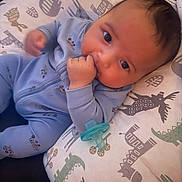 Dominic joined the competition — help win amazing prizes! baby, infant, pacifier, onesie, blanket, animal_print, blue_clothing, hand_in_mouth, cheeks, lying_down, pillow, nursery, cute, portrait, closeup, soft_light, pattern, gaze, sleepwear, baby_bed