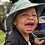 child, toddler, smiling, laughing, hat, green_hat, outdoor, daylight, face, happy, closeup, baby, clothing, park, nature, expression, person, young_child, joy, cute