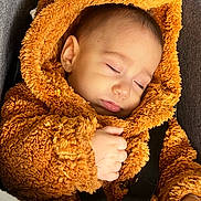 Isaac a rejoint le concours — aidez-le/la à gagner de superbes lots ! baby, car_seat, child, cozy, cute, face, fur_texture, hand, indoors, infant, orange_clothing, peaceful, portrait, resting, seatbelt, sleeping, soft, teddy_bear_onesie, warm_clothing, young_child