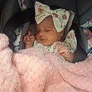 Amelia is registered to the contest to win money with this photo: baby, infant, car_seat, blanket, pink, bow, sleeping, child, face, clothing, floral, cute, soft, comfort, resting, young, person, toddler, indoors, peaceful