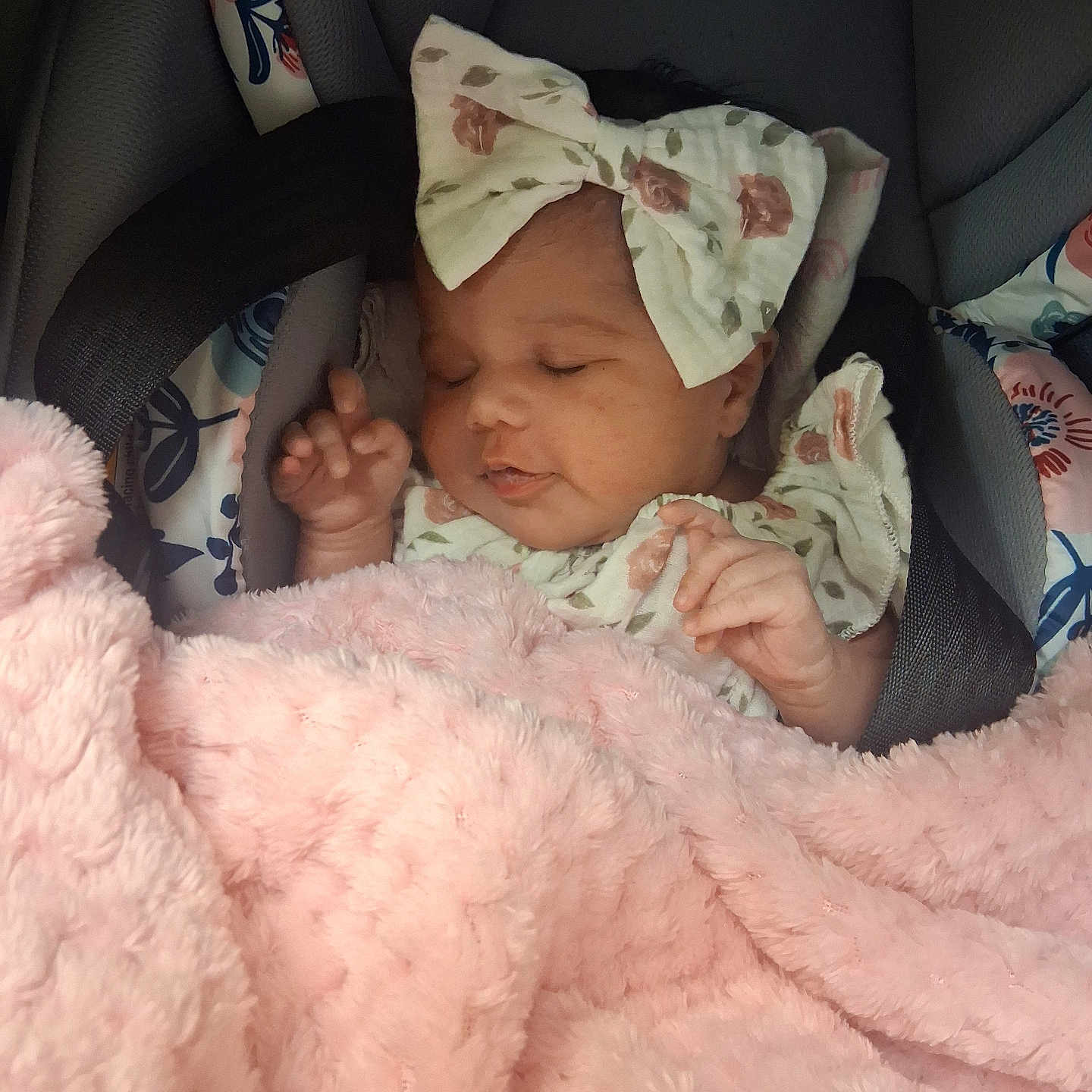 Amelia is registered to the contest to win money with this photo: baby, infant, car_seat, blanket, pink, bow, sleeping, child, face, clothing, floral, cute, soft, comfort, resting, young, person, toddler, indoors, peaceful