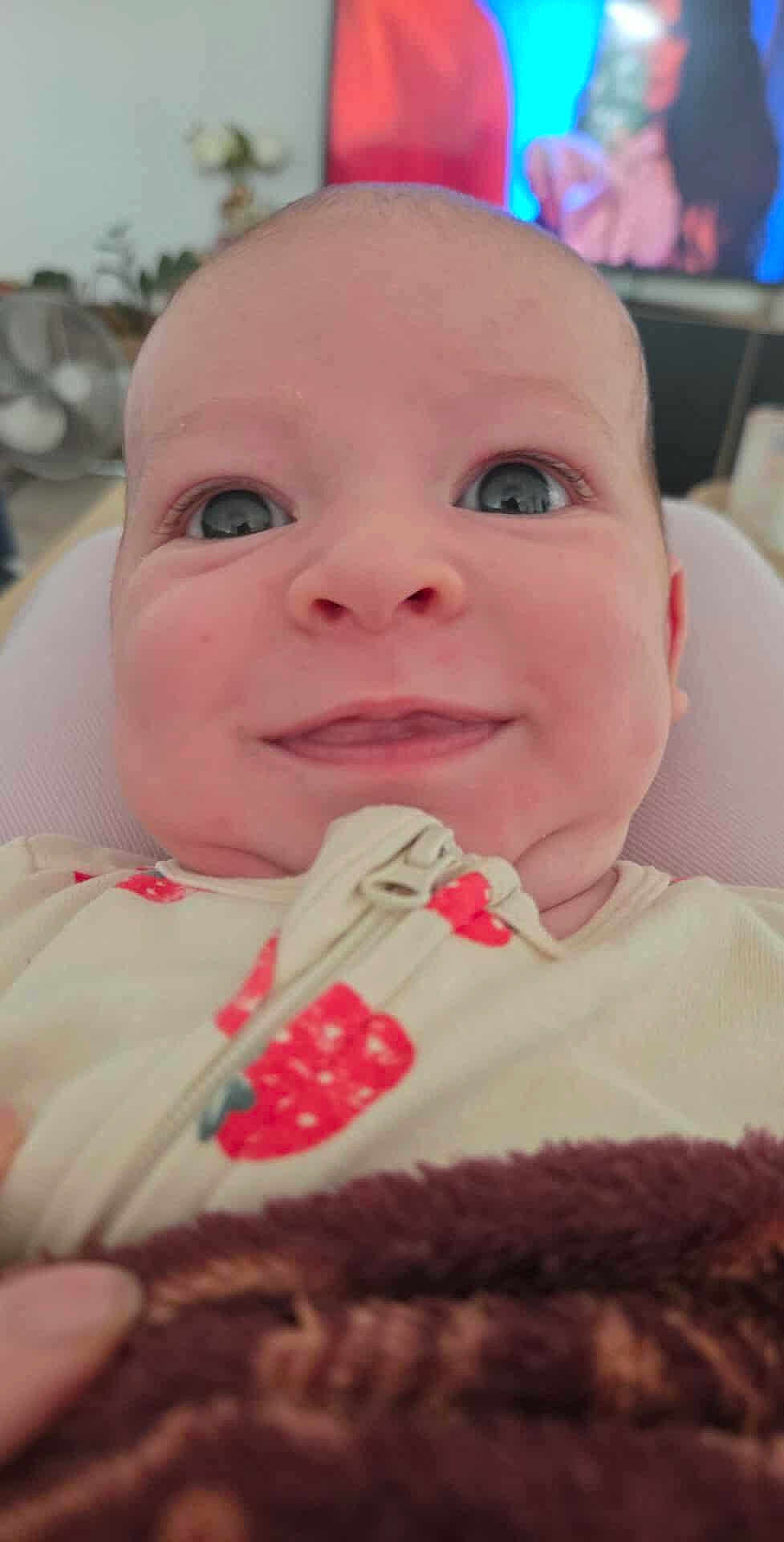 Noa a rejoint le concours — aidez-le/la à gagner de superbes lots ! baby, close_up, face, smile, eyes, infant, blanket, clothing, indoor, portrait, cute, expression, child, young, cozy, home, soft_focus, warm, person, newborn