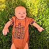 Kyler joined the competition — help win amazing prizes! baby, infant, onesie, clothing, grass, yellow_flowers, outdoor, nature, greenery, child, person, cute, portrait, sunlight, summer, lying_down, expression, skin, head, hands