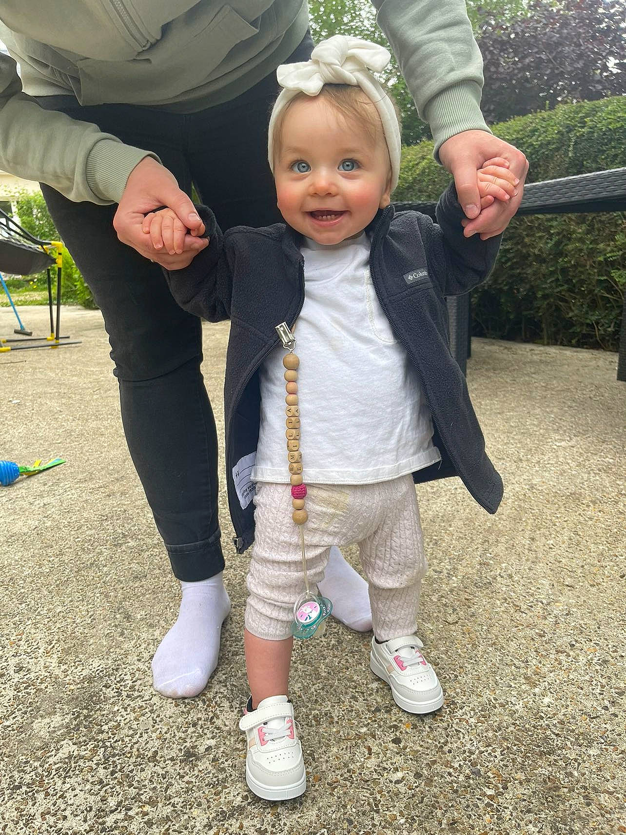 Emilia a rejoint le concours — aidez-le/la à gagner de superbes lots ! baby, chair, child, event, fun, gesture, grass, happy, holding_hands, joy, leg, leisure, people_in_nature, person, plant, recreation, smile, sneakers, thumb, toddler